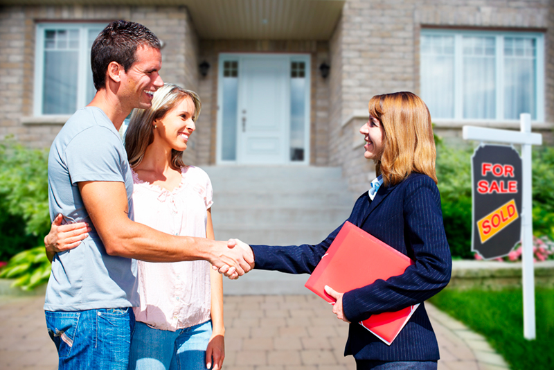 Happy couple shaking hands with Realtor