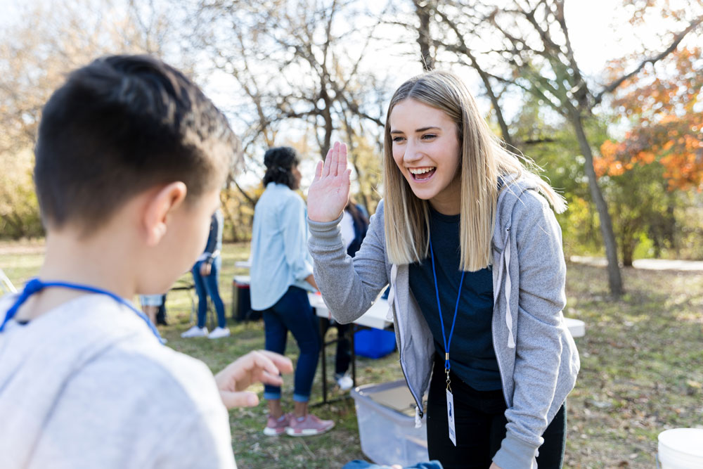 Happy girl giving high-five to young boy.