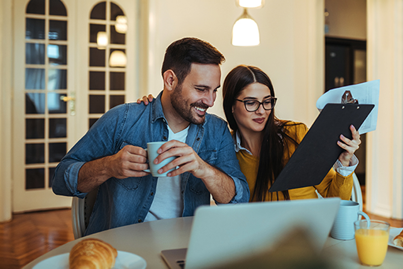 Couple sitting at kitchen table going through a to-do list