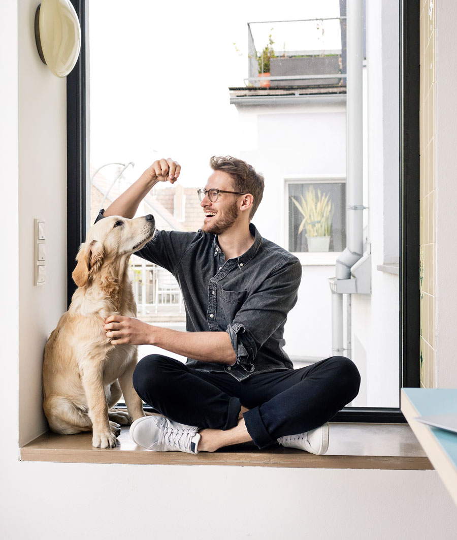 A Guy and his dog sitting in a window sill
