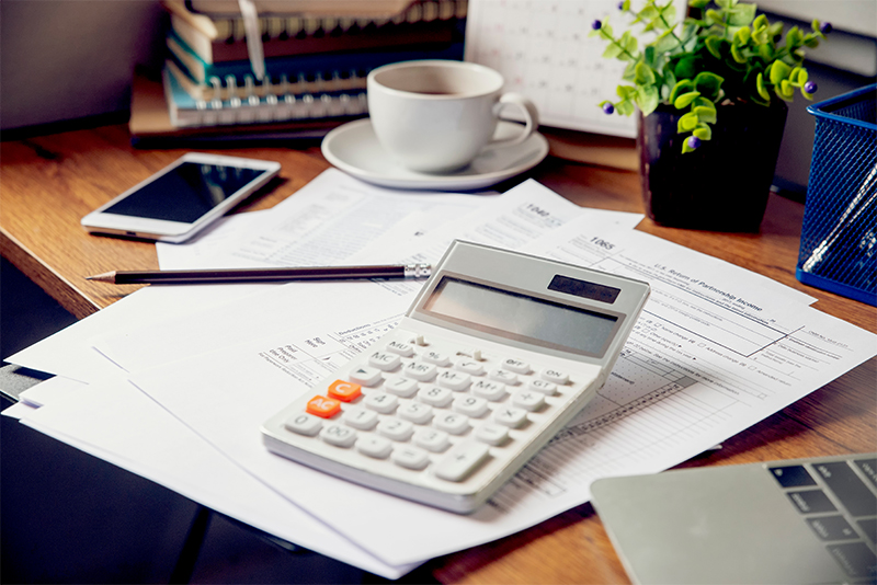 Calculator and tax documents on desk at home
