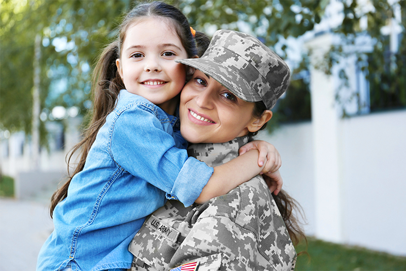 Happy military mom with daughter in arms