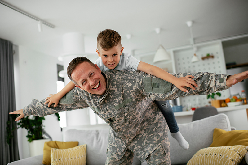 Happy military veteran having fun at home with son