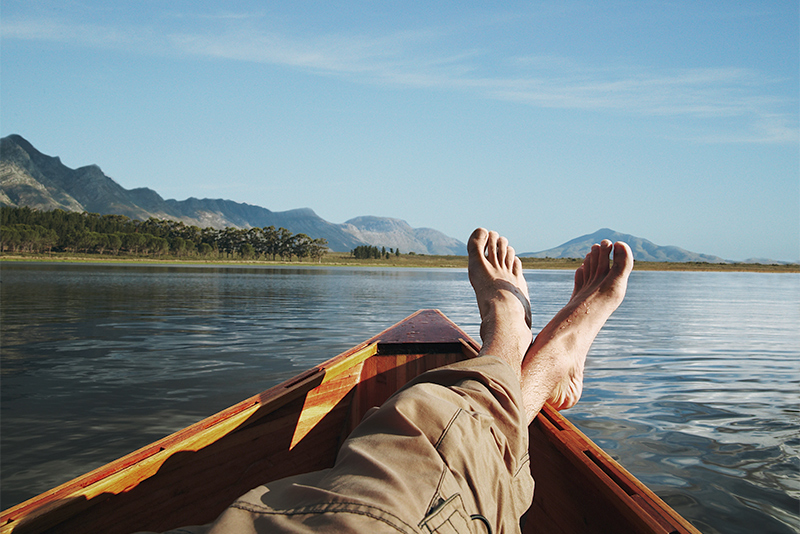 Young man lying in boat on a lake