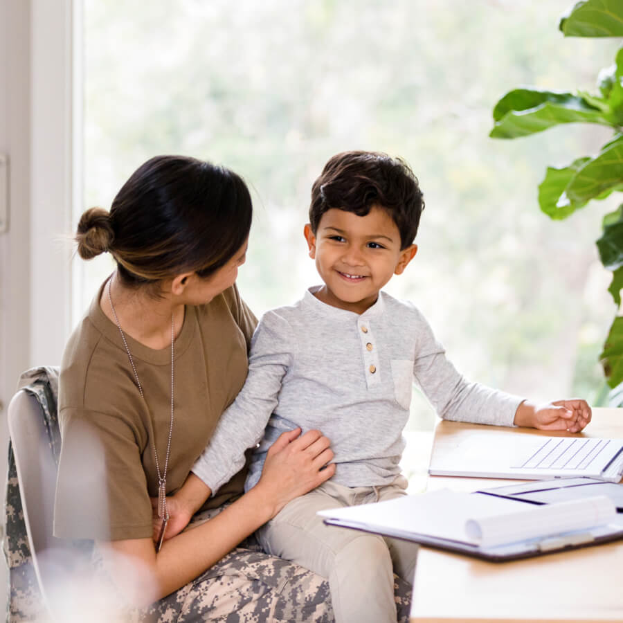 Happy veteran mom with young son in home.