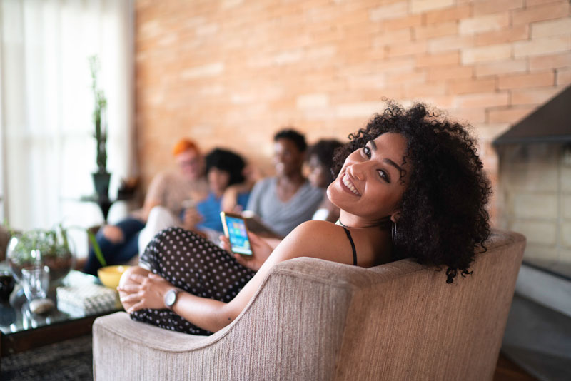 Happy young woman sitting on sofa chair