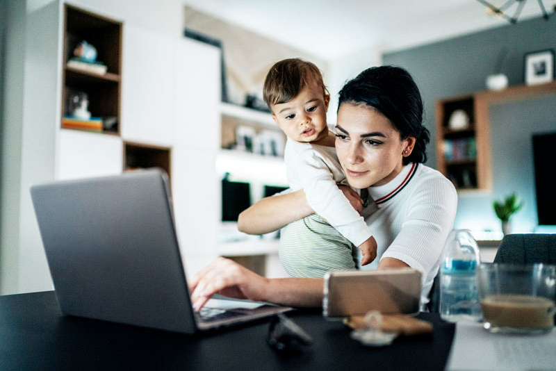 A Mother And Daughter Sitting In Front Of A Laptop