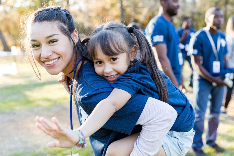 Happy mom and daughter playing in park