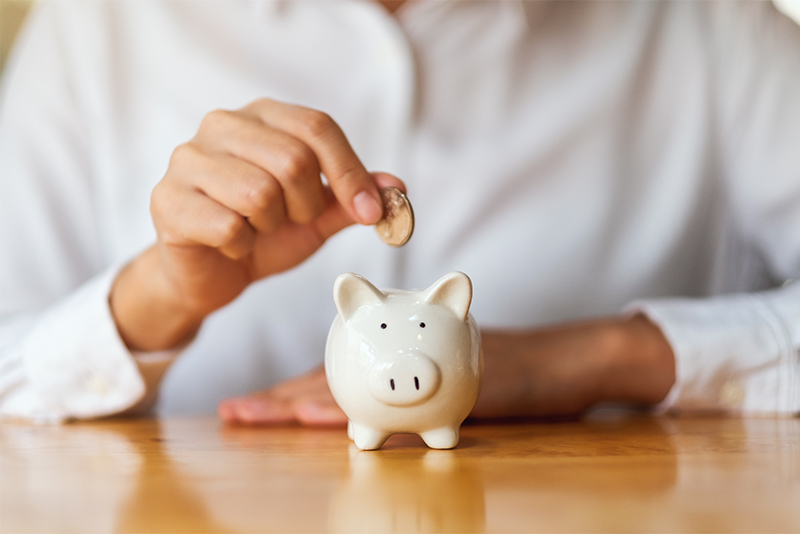 A woman putting coins into piggy bank for saving money