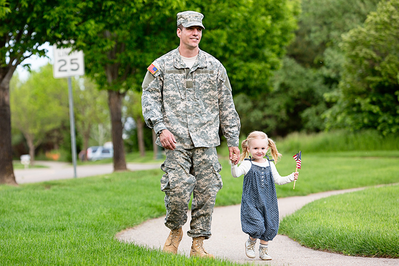 Veteran soldier in uniform having fun with his young daughter