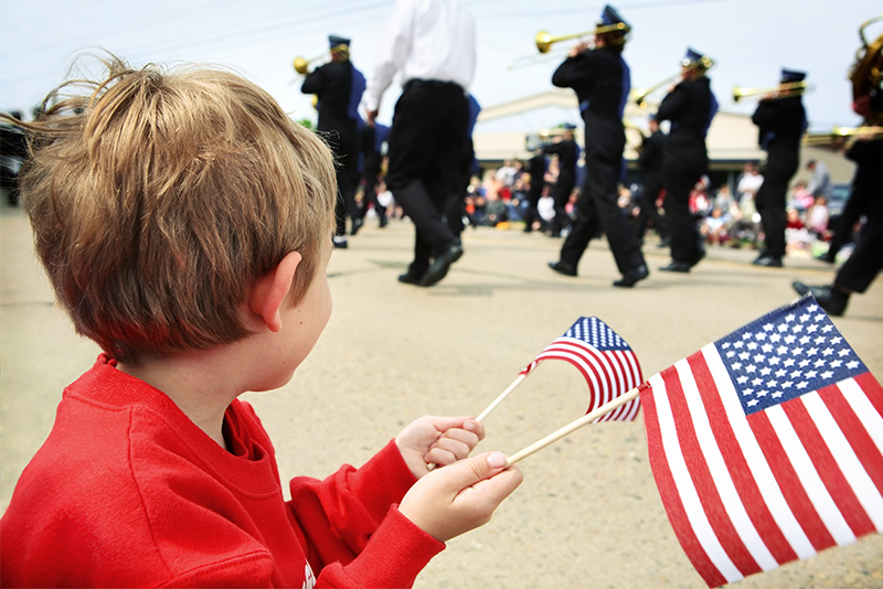 Young Boy Holding American Flag During Memorial Day Parade