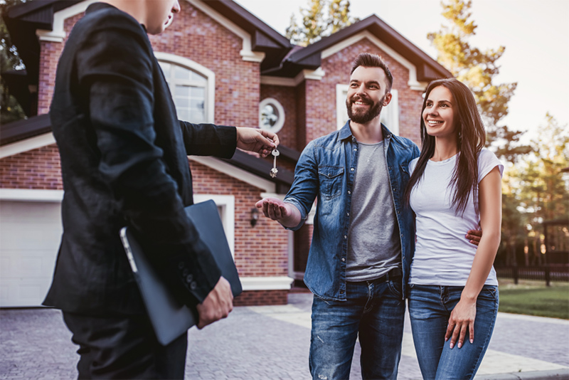 Happy couple is taking keys from their new house