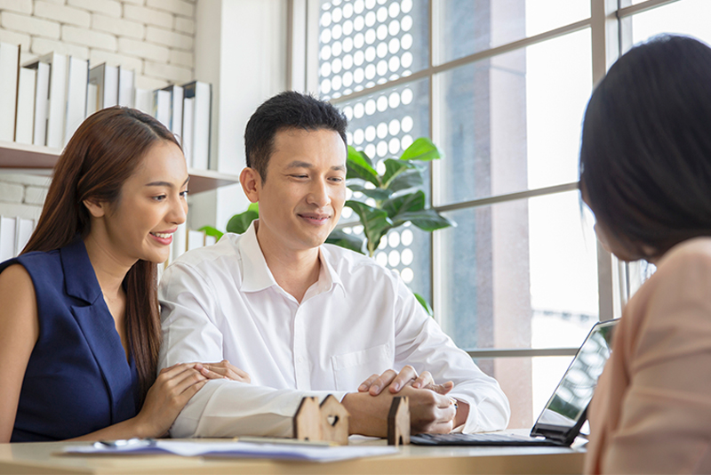 Happy Young Loving Couple Talking To Their Real Estate Agent