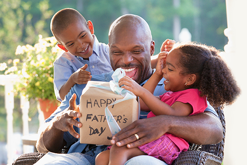 Boy And Girl Watching Father Open Father's Day Gift