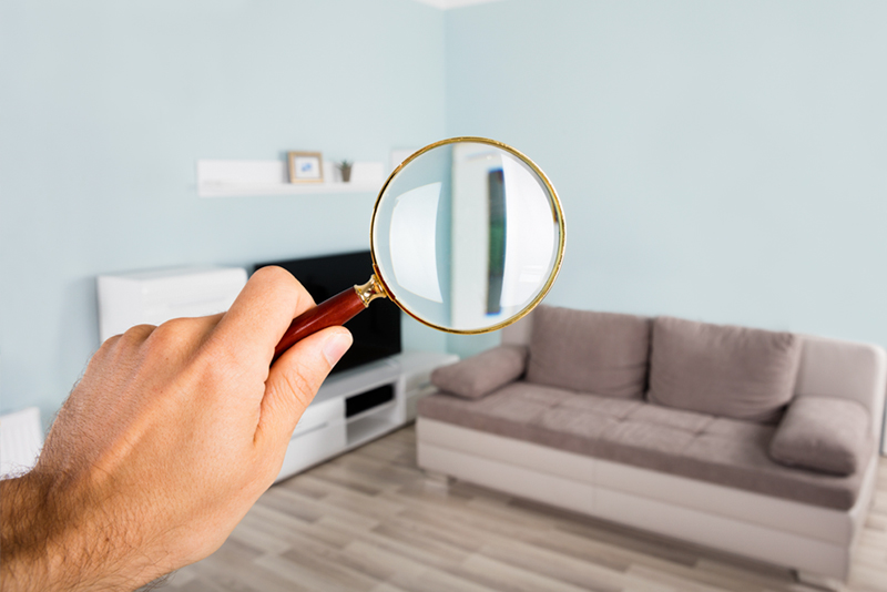 Man holding magnifying glass in living room