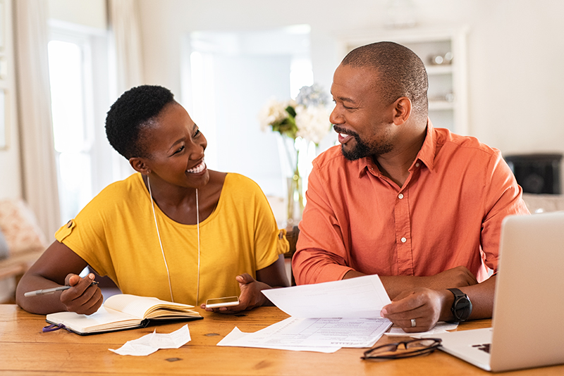 Couple Sitting And Managing Expenses At Home