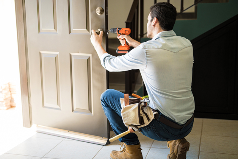 Man Working As Handyman Fixing A Door Lock