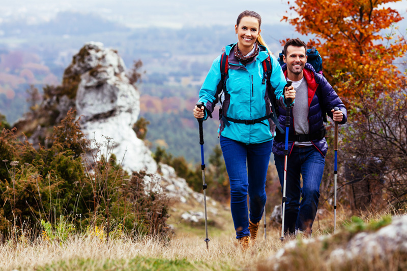 Couple Backpackers hiking on the path in mountains 