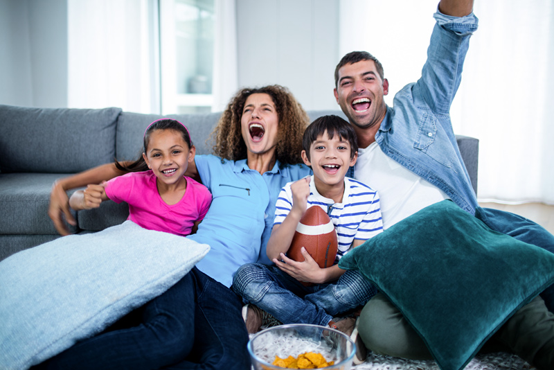 Family watching american football on tv at home