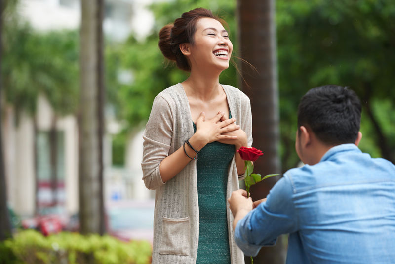 man proposing to smiling girlfriend