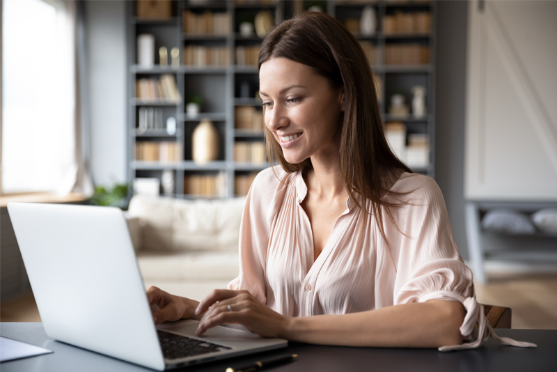 Happy Woman working on computer at home