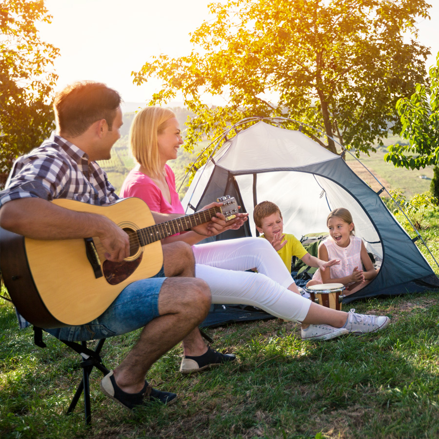 Happy family camping and playing music
