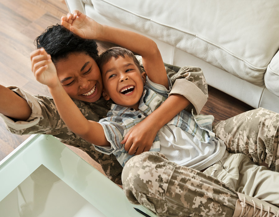 Happy veteran mother and her son lying on floor Happy veteran mother and her son lying on floor