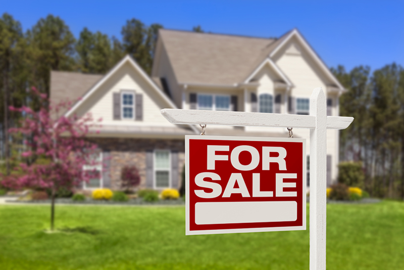 Beautiful home with For Sale sign in focus