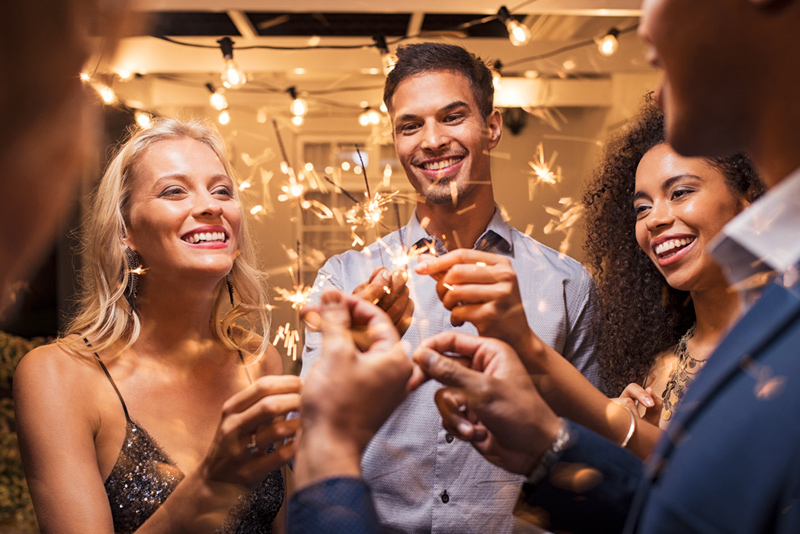 Happy group of people at new years eve party with sparklers