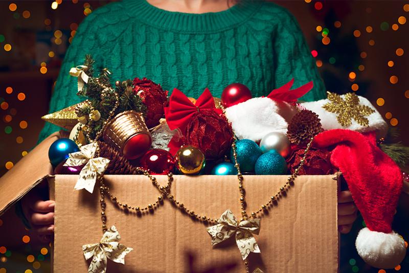 Woman holding holiday decorations in storage box