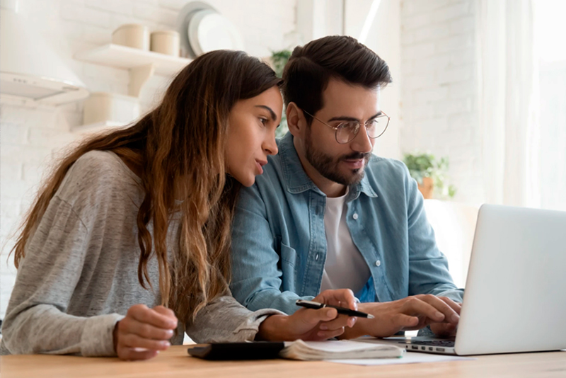 Couple working on laptop at kitchen table