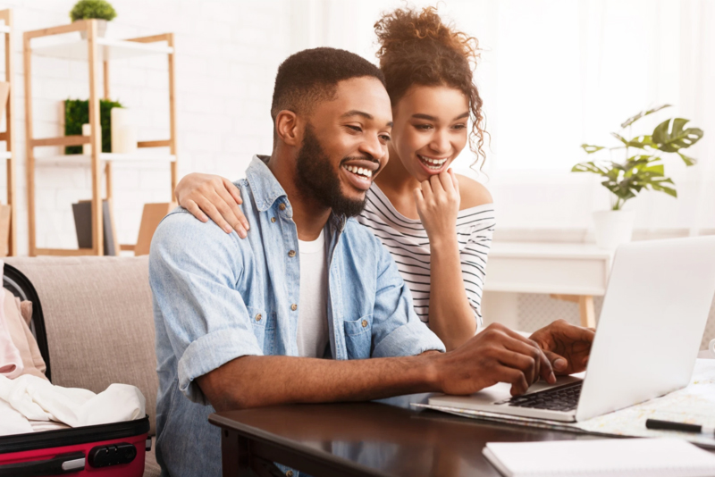 Happy couple working with laptop on coffee table