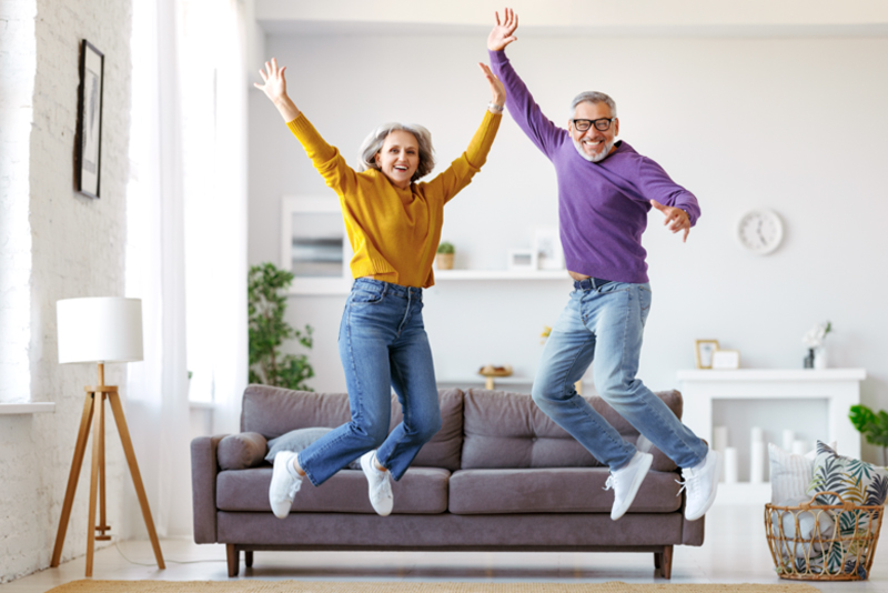 Couple jumping in the air in their minimalist living room