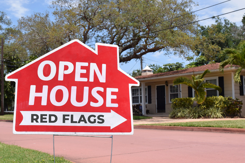 Red open house real estate sign in suburban neighborhood