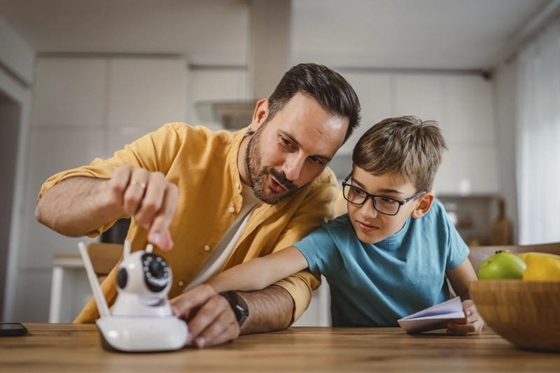 Father and son setting up security camera