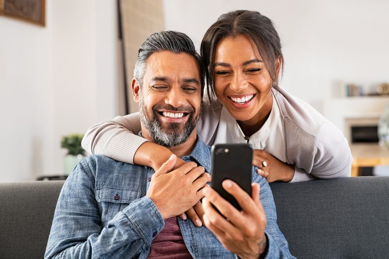 couple looking at phone in living room 